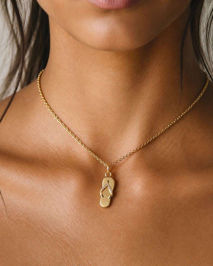 A gold flip-flop pendant on a fine chain