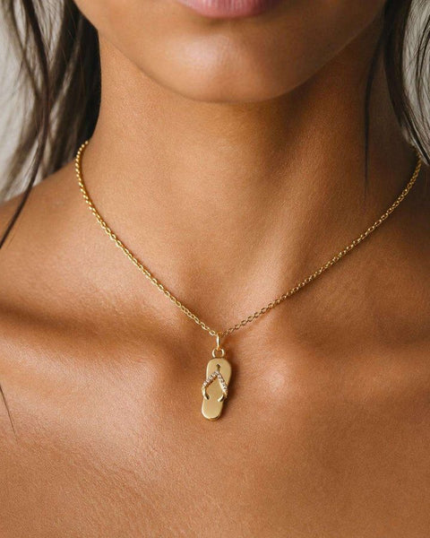 A gold flip-flop pendant on a fine chain